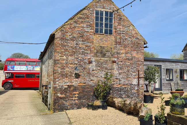 Bus parked behnd a barn-like building at Artelium near Brighton